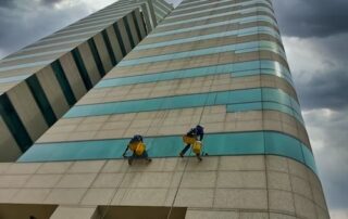 two workers painting a skyscraper