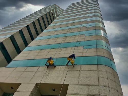 two workers painting a skyscraper