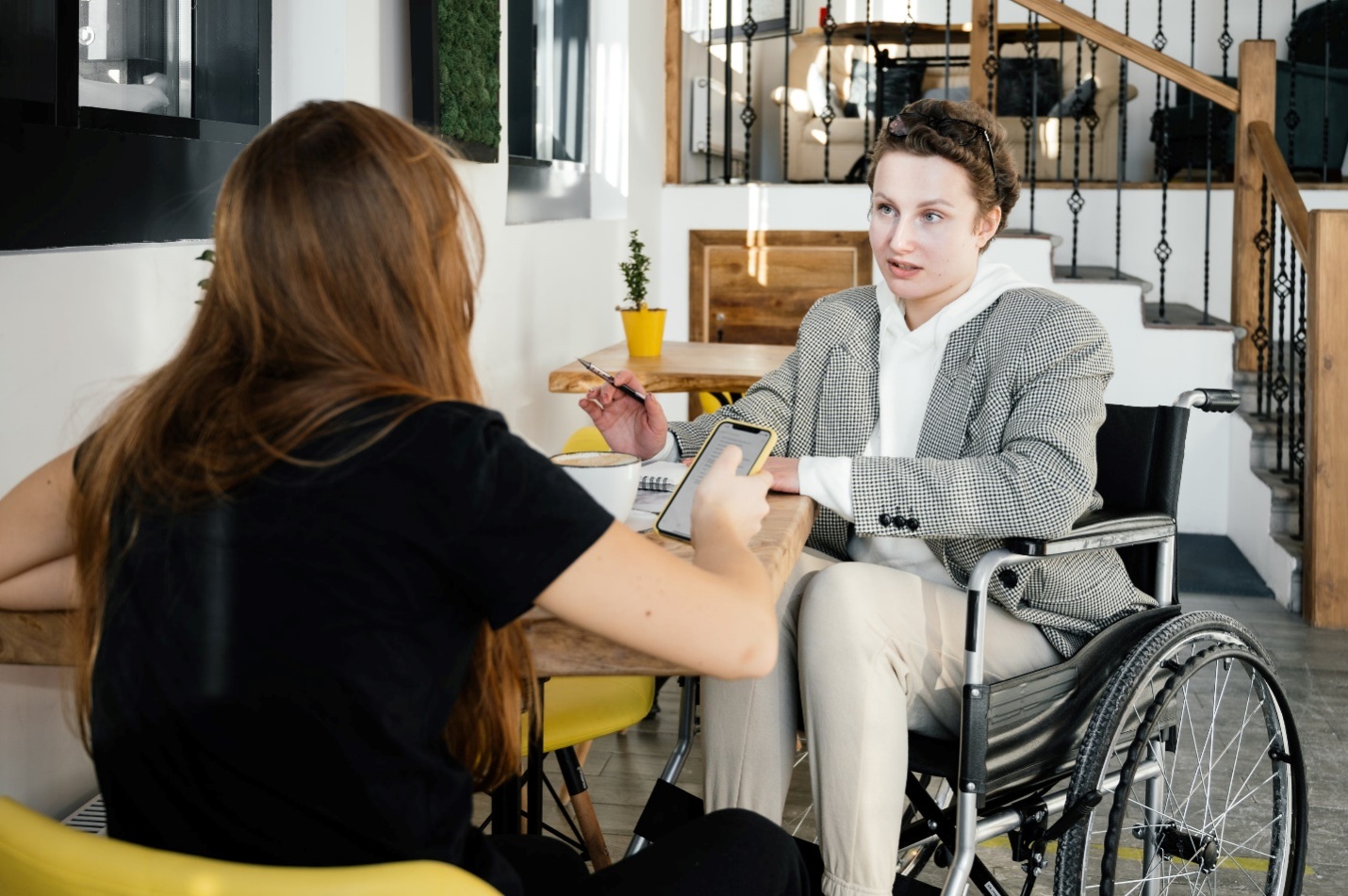 Woman in a wheelchair talking to another woman