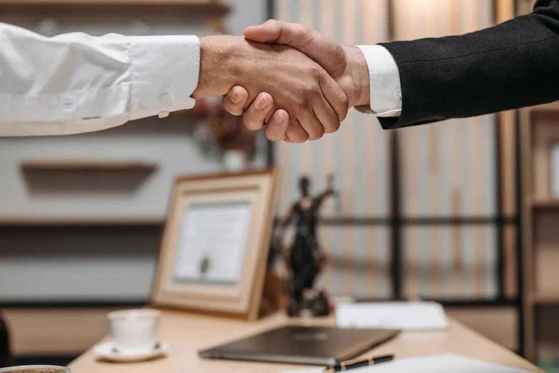 a client and their lawyer shaking hands at the lawyer's office