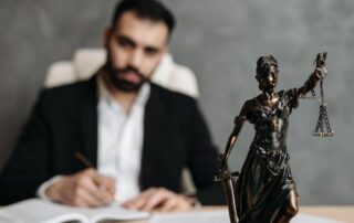 A lawyer in front of a statue depicting justice