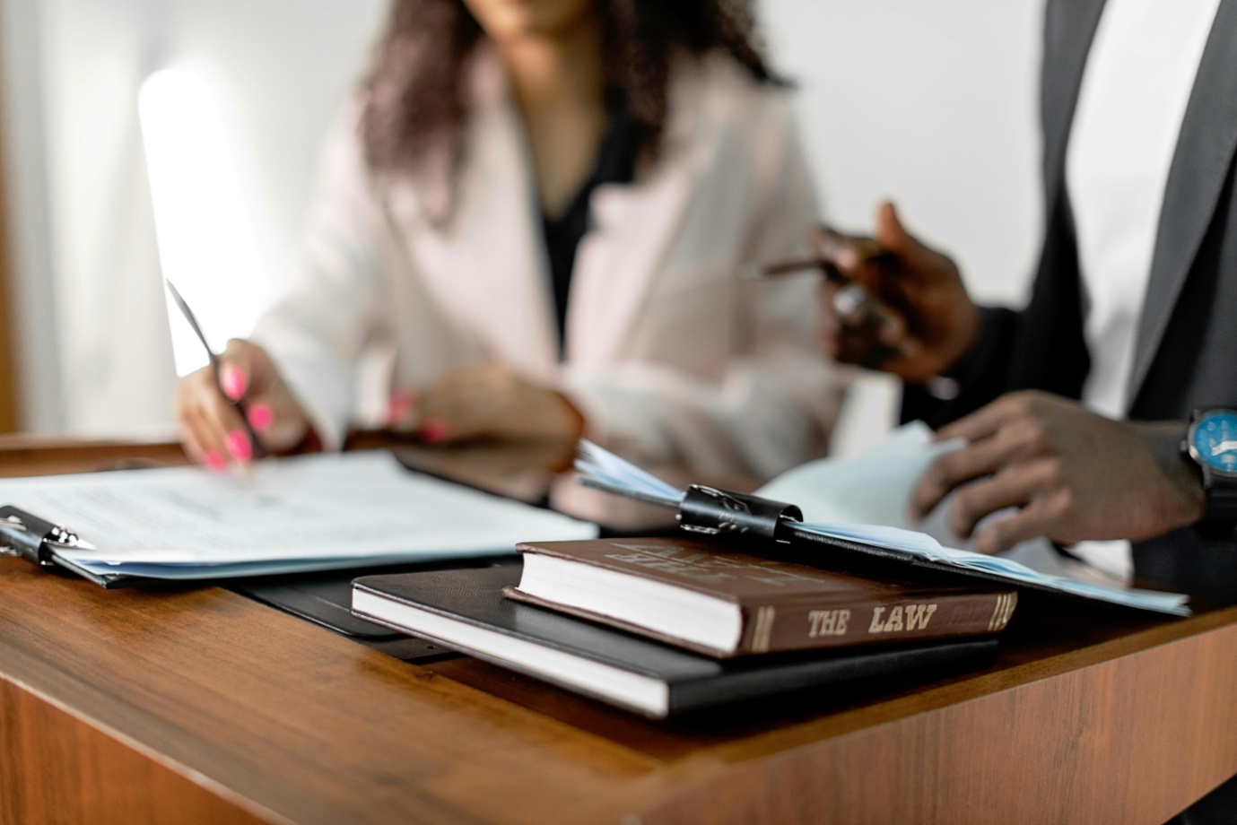 One man and one woman discussing legal matters with documents on the table