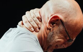 Man experiencing neck pain due to a work-related or pre-existing condition