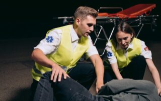 Two medical staff members assisting a fallen worker