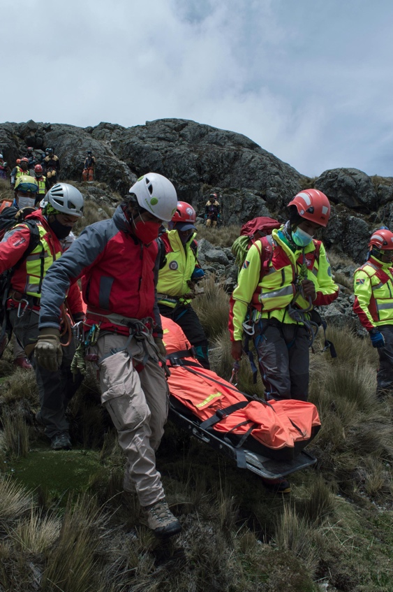 Rescue team assisting an injured person on a mountainside