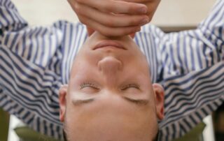 Man sitting at a home office desk looking up from his computer during work hours