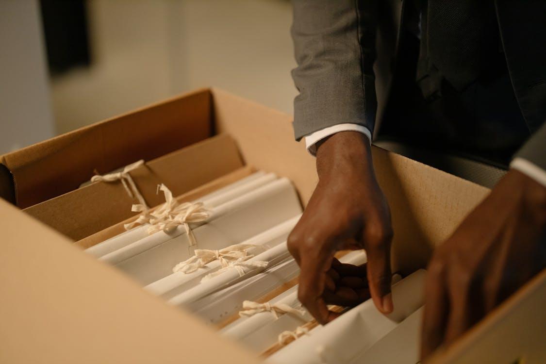 A close-up shot of a person holding a box of files.
