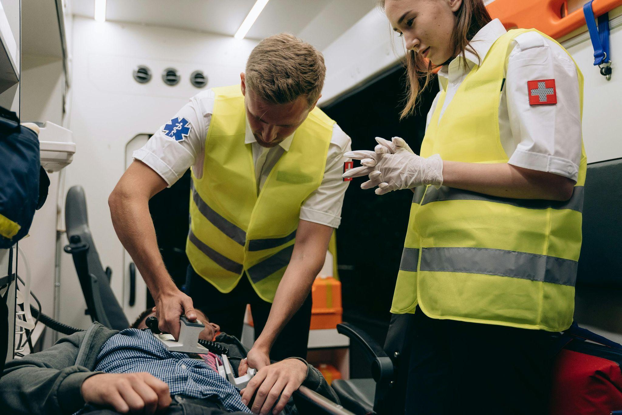 Two paramedics using a defibrillator on a patient. 