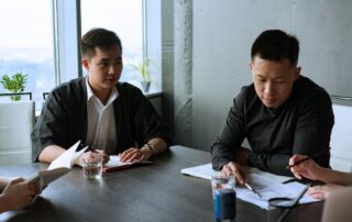 Two workers reviewing documents together on a table.