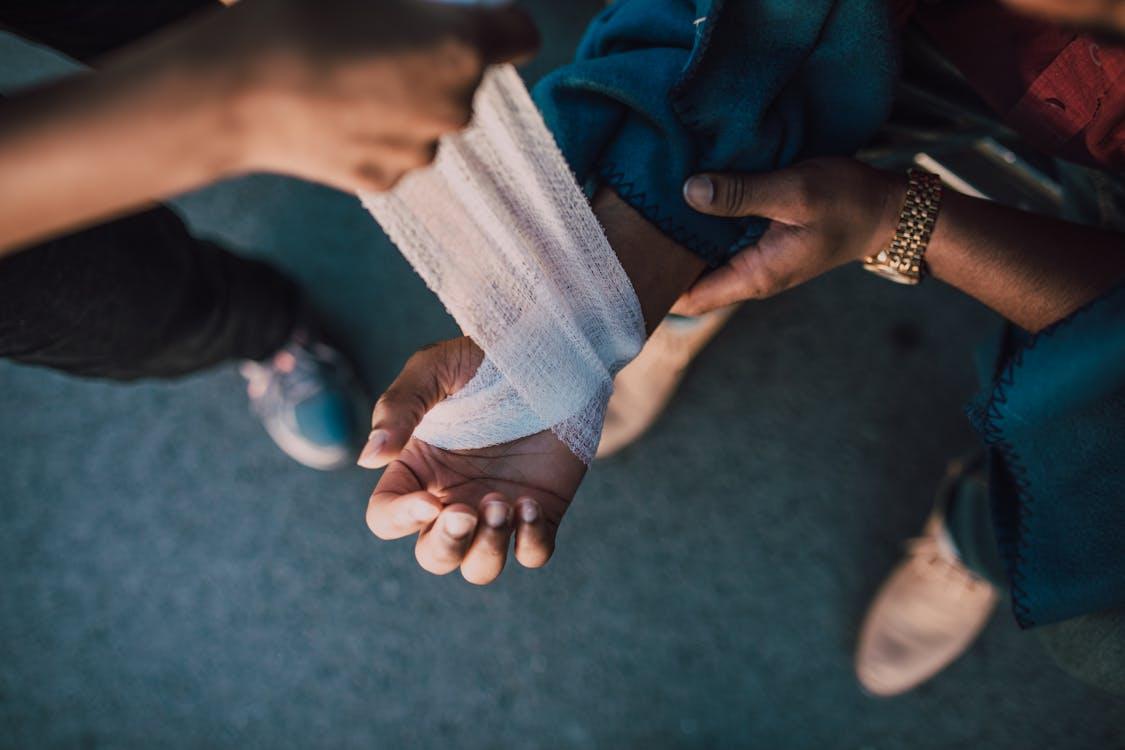 a person putting a bandage on another person's hand