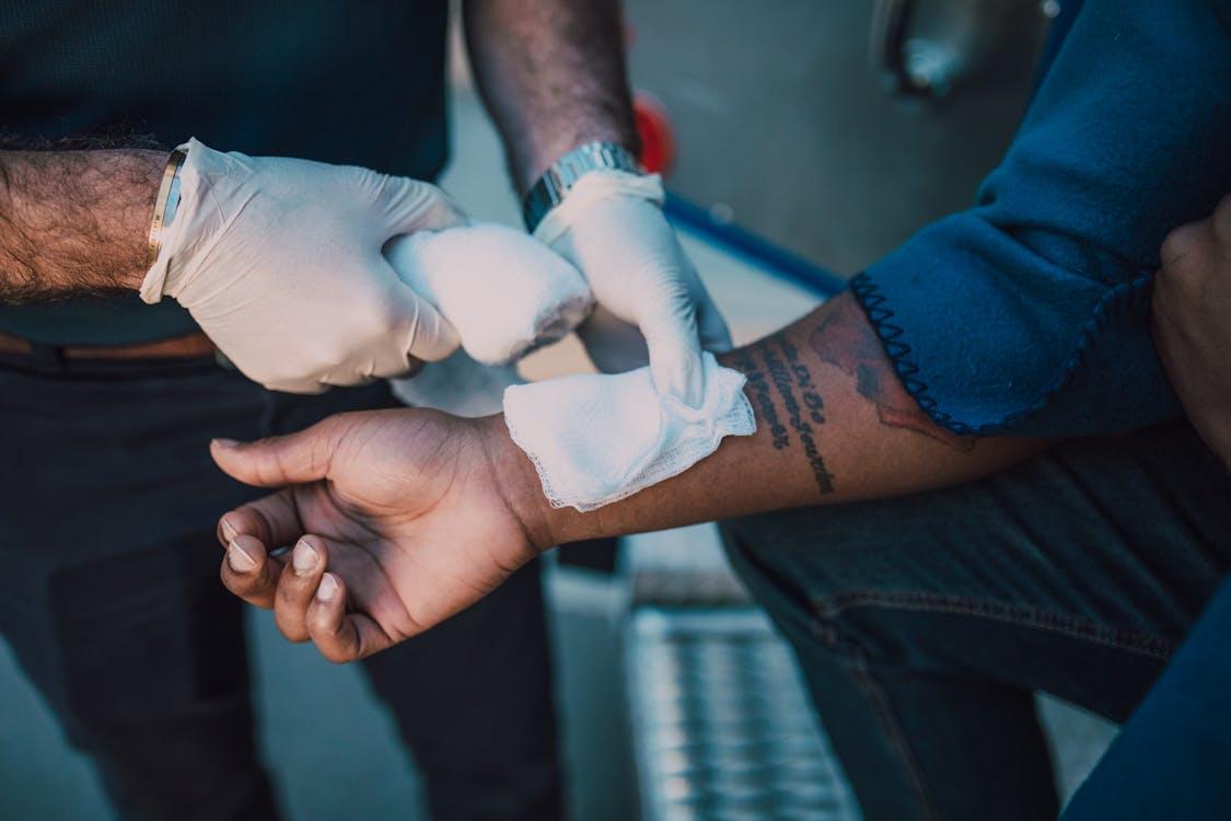 a person putting a bandage on another person’s hand