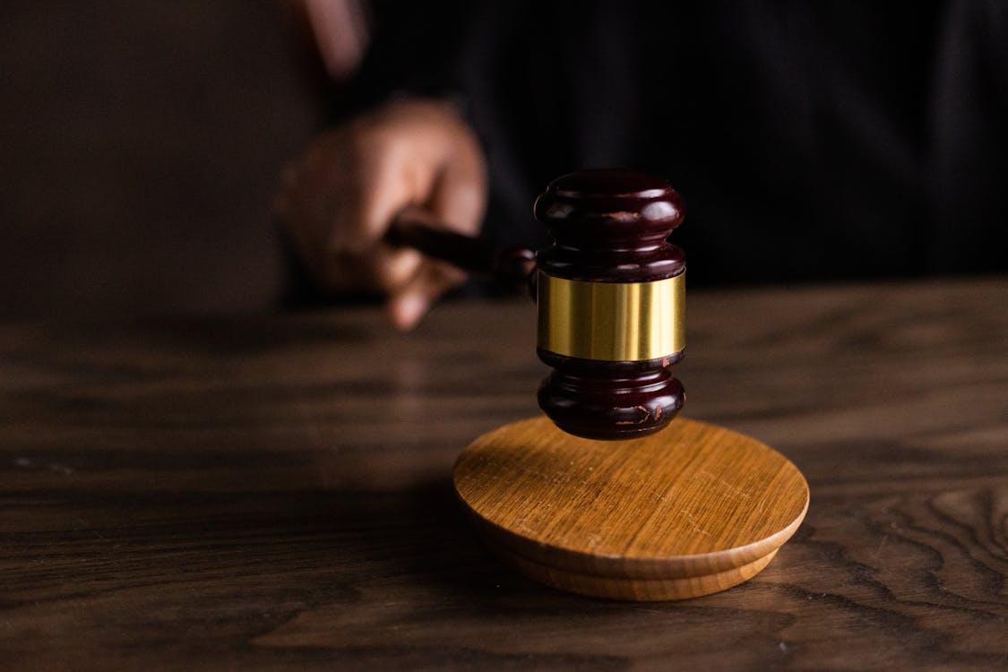 a wooden gavel on a wooden table being used by a judge