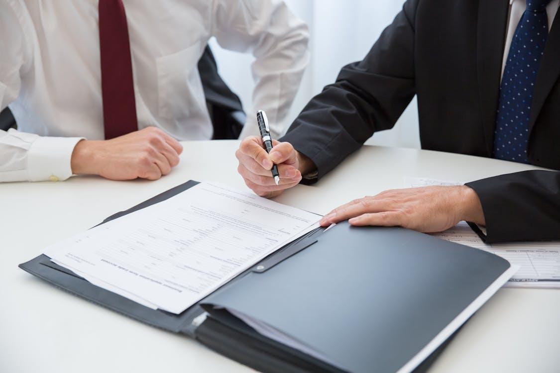 a person signing a settlement in the presence of a lawyer