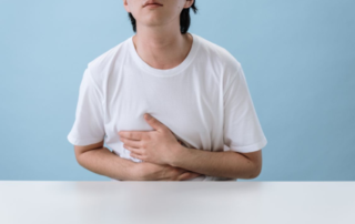 Worker holding chest in pain due to cumulative trauma from repetitive workplace stress