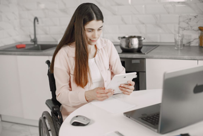 Woman in wheelchair using a tablet to research her permanent disability workers' compensation claim