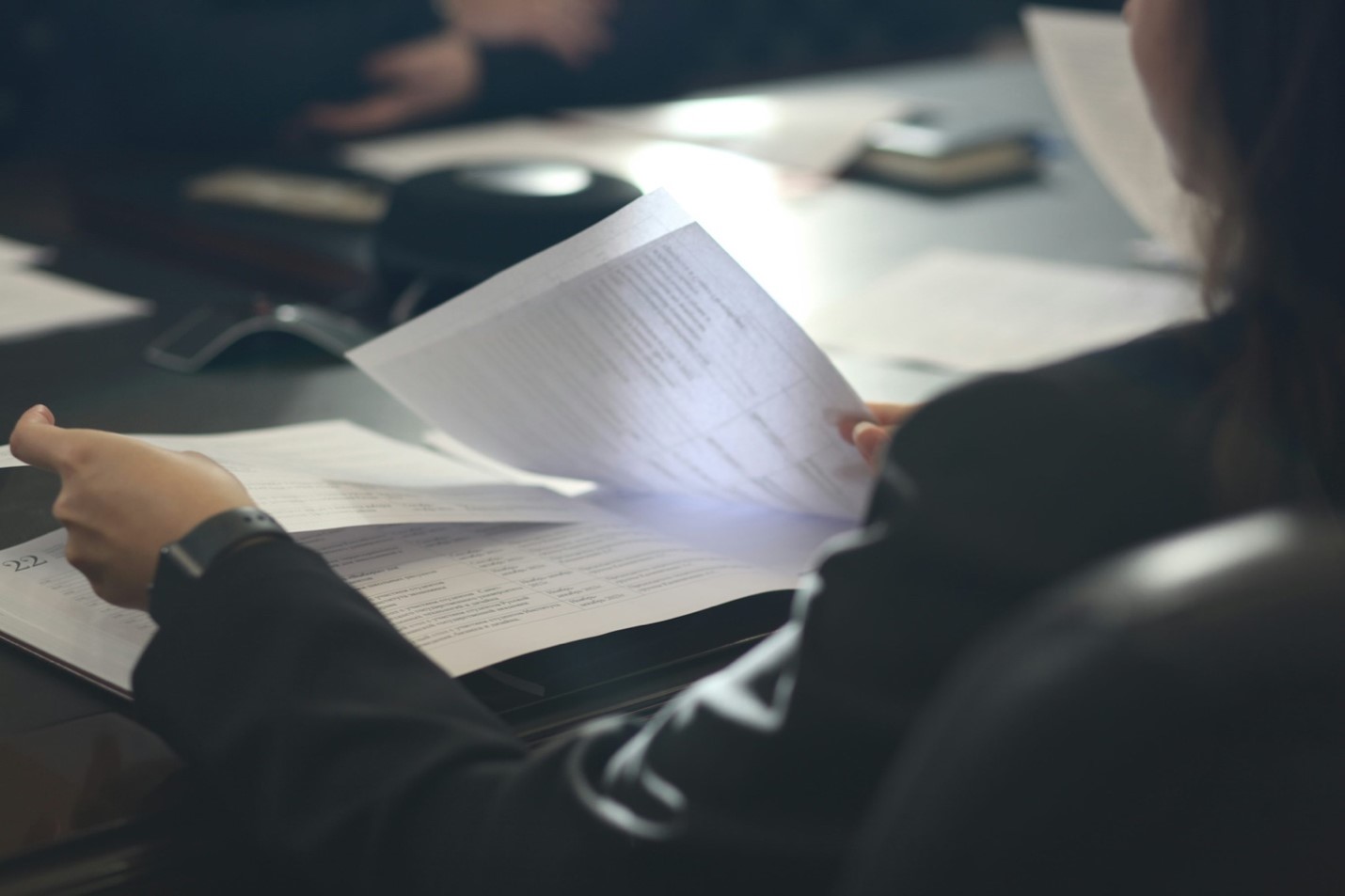 Individual carefully reviewing claim documents and paperwork related to a workers’ compensation case