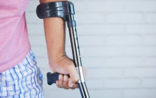 Injured worker using crutches while recovering from a serious long-term workplace injury.