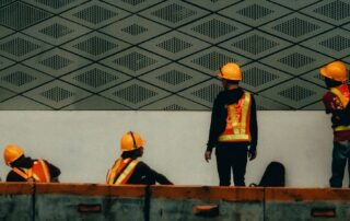 Construction workers performing tasks at an active job site while following workplace safety procedures in California.