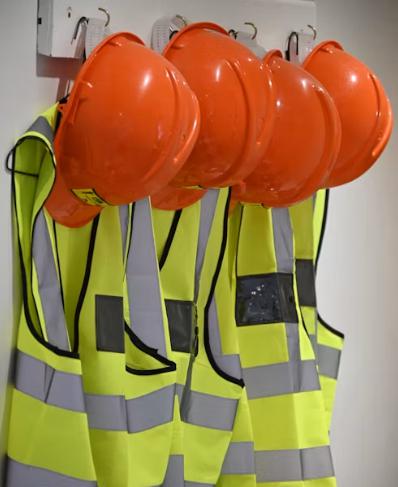Workers wearing protective uniforms and safety helmets before beginning work at an industrial job site.