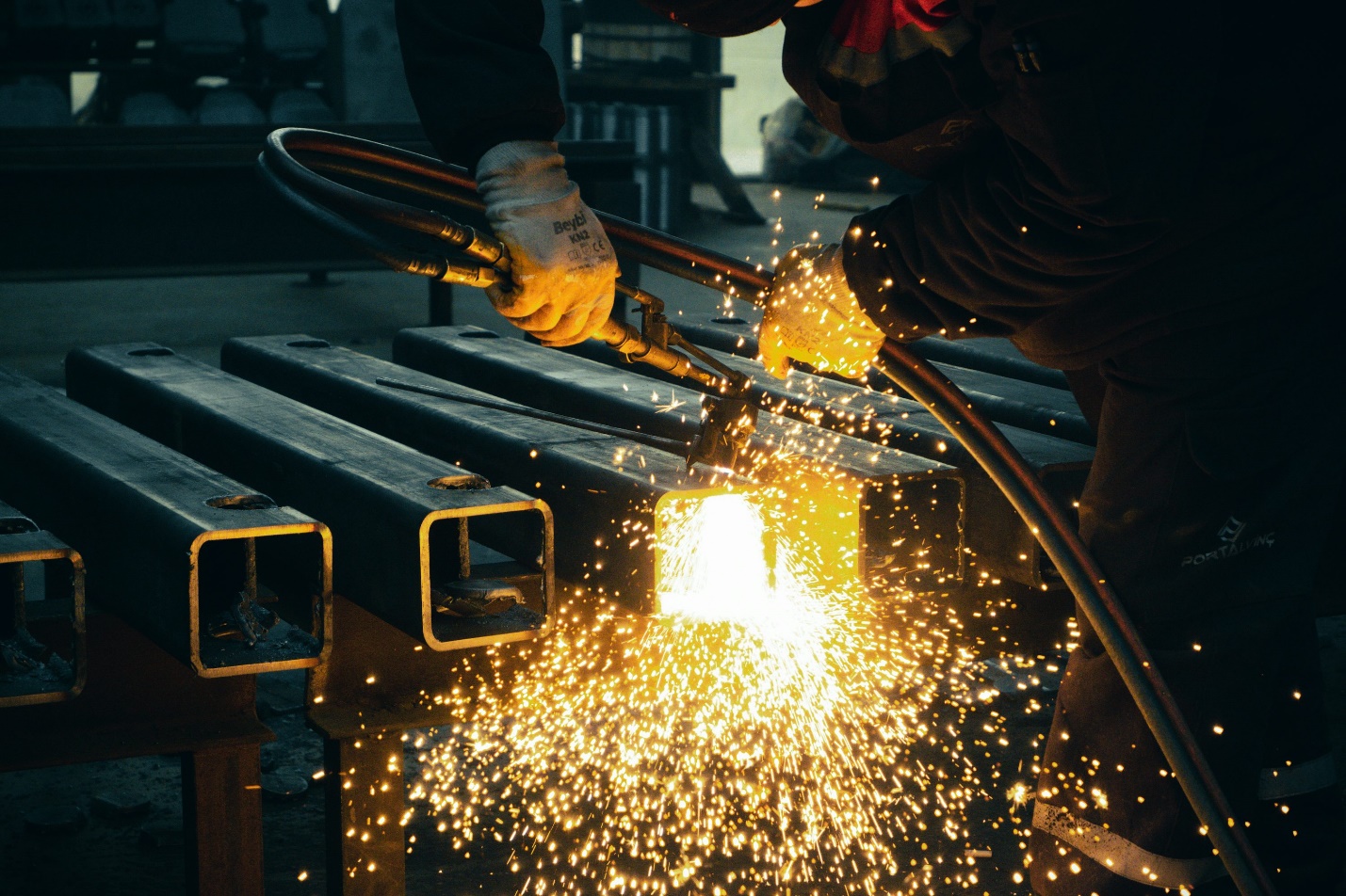 Worker performing outdoor job duties under intense heat while wearing protective clothing and safety equipment.