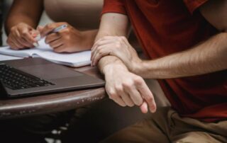 Office employee experiencing wrist discomfort while working at a computer.