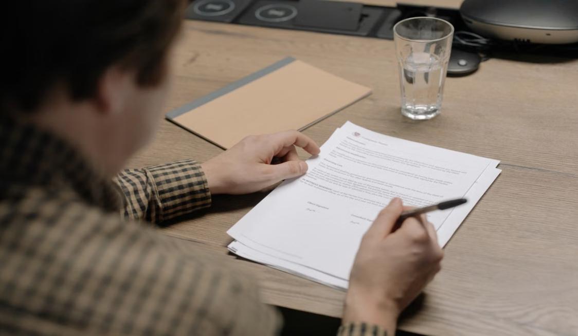 Professional reviewing workplace injury documentation with an office employee.
