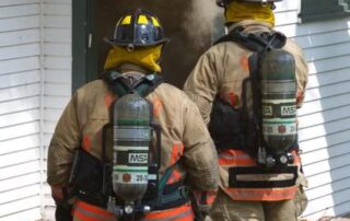 An image of firefighters before entering a burning house