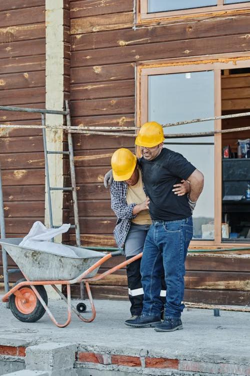 An image of a construction worker helping his injured colleague